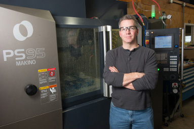 Bob Wolcott, president and owner of Wolcott Design Services, stands next to his latest high-performance machining investment, the Makino PS95 vertical machining center.
